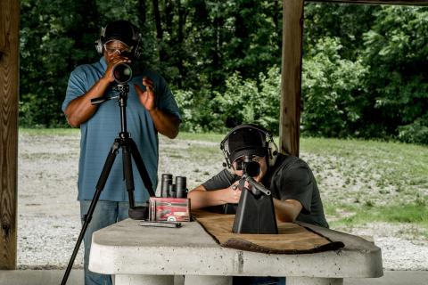 Two people preparing to shoot firearms at a range