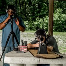 Two people preparing to shoot firearms at a range